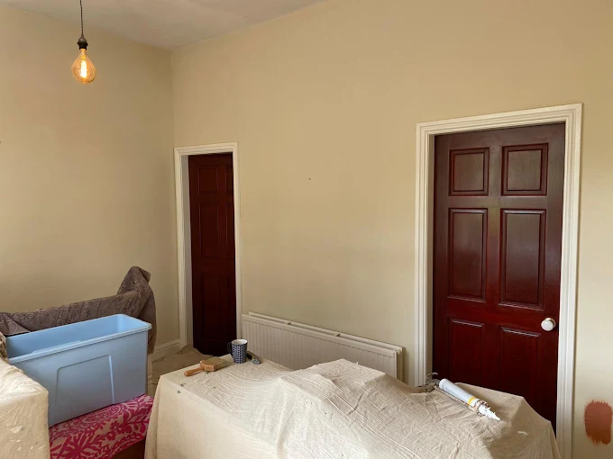 Period hallway repainted by Home Hues in warm cream, original mahogany-stained doors retained