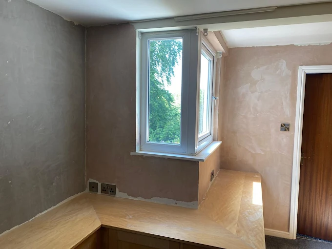 Bedroom freshly skimmed with pink plaster by Home Hues, drying around a large bay window