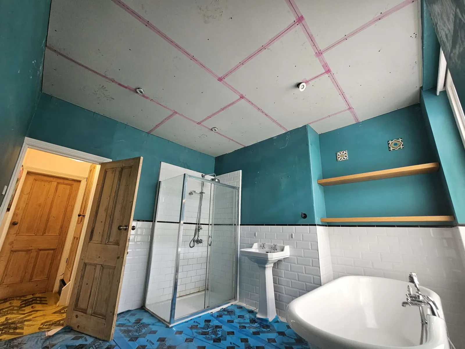 New plasterboard bathroom ceiling with joints taped, tiles and floor protected