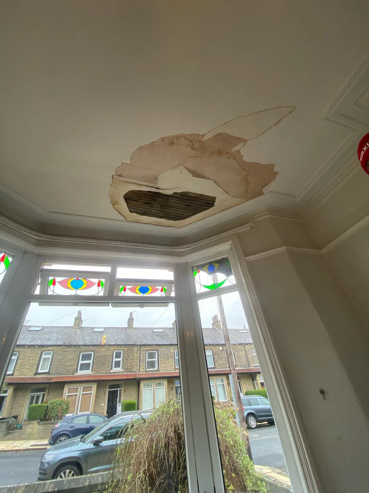 Bay window ceiling with a large section of plaster dropped after water damage