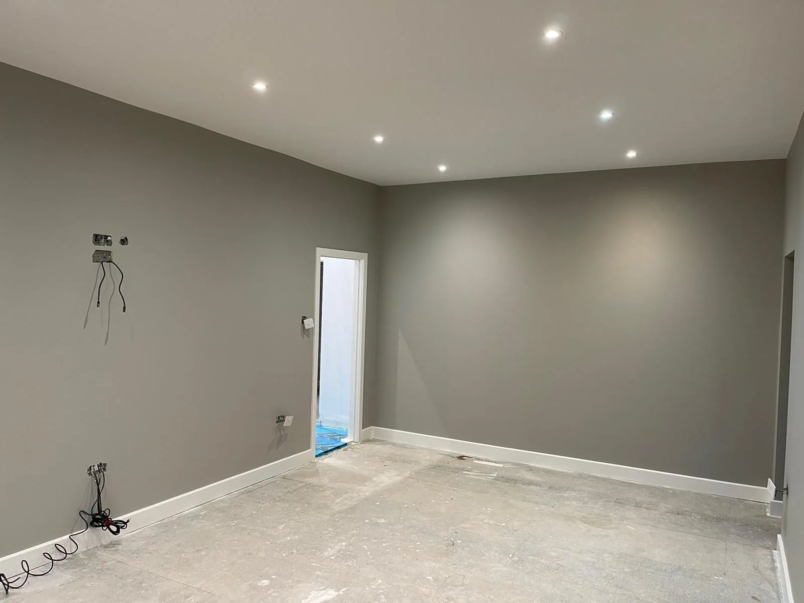 Commercial unit finished in warm grey with recessed lighting and crisp white skirting