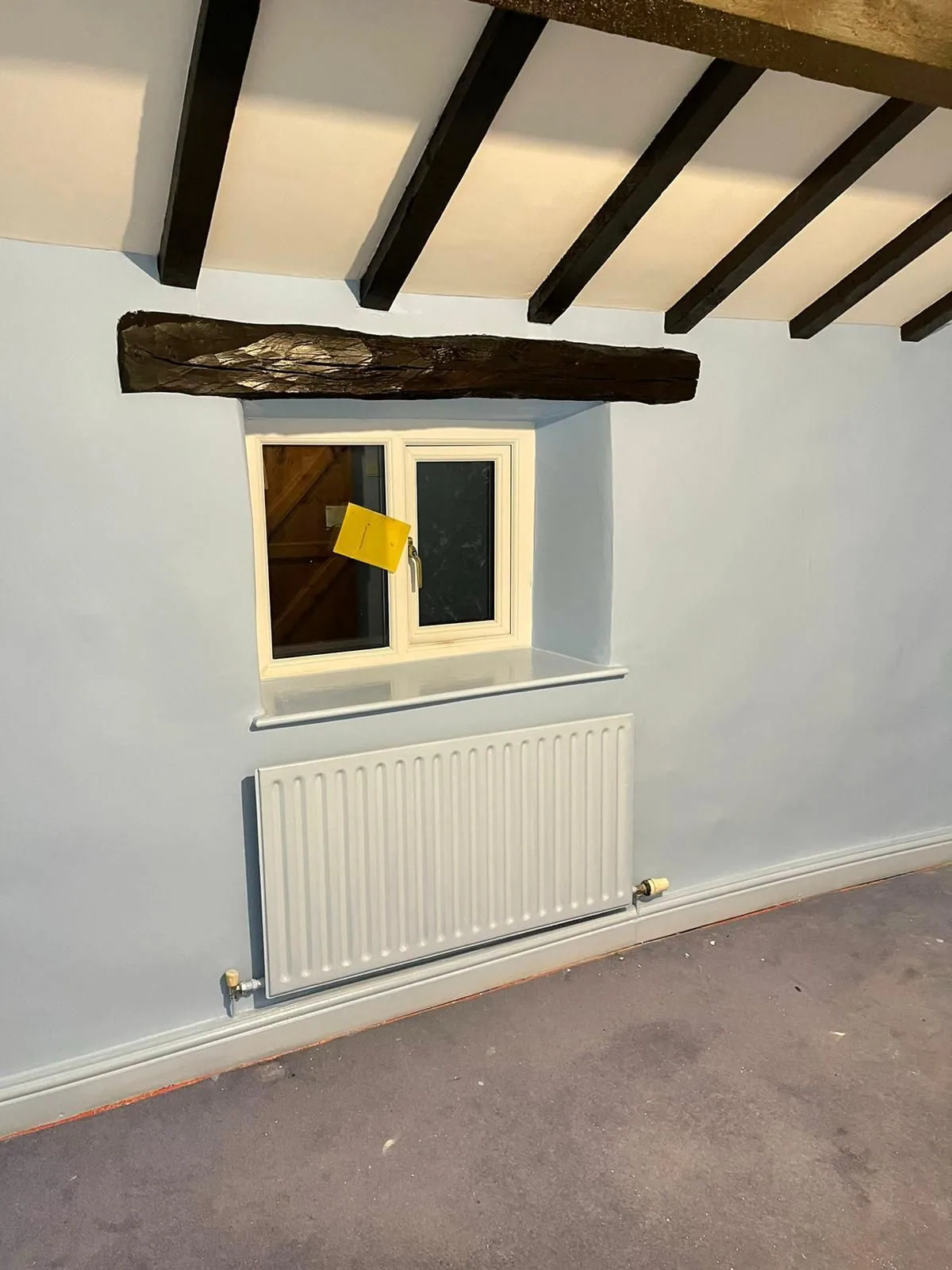 Same cottage bedroom finished in soft blue with original beams retained and repainted