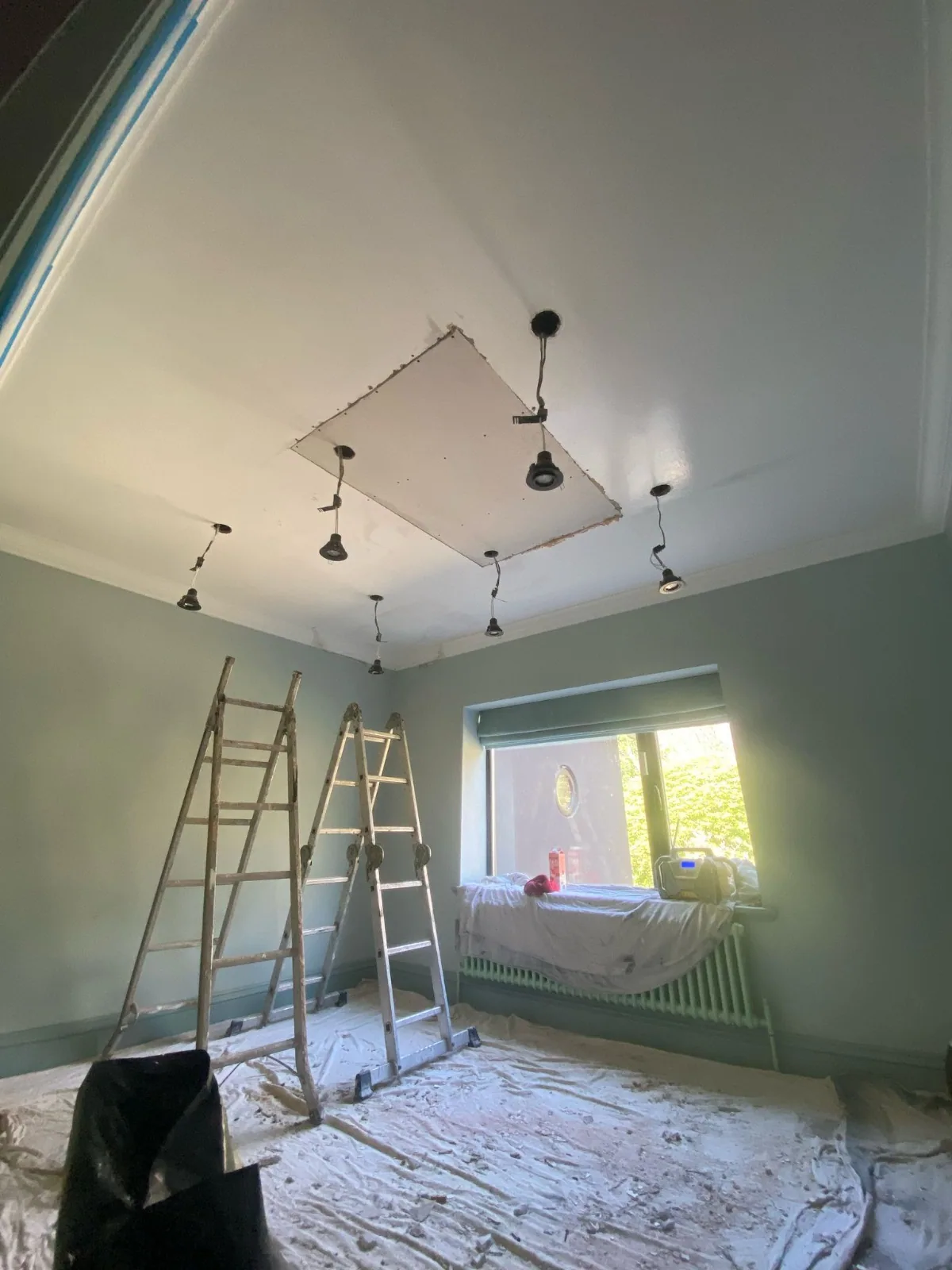 Period bedroom ceiling repaired and freshly skimmed after a collapse, original wallpaper masked off